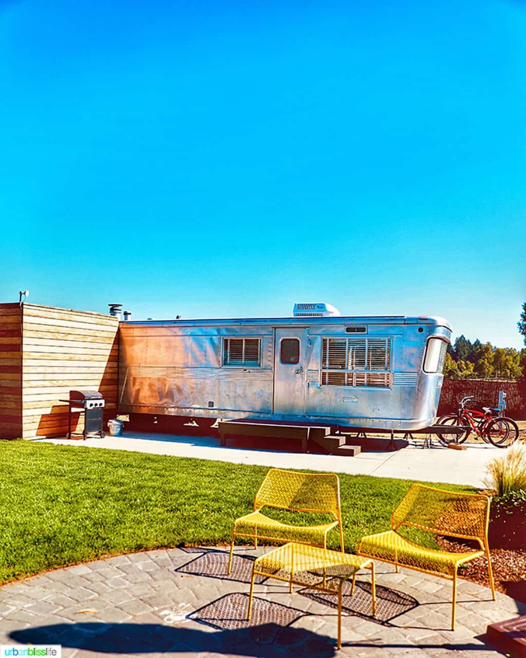 Exterior of the mansion airstream and yellow chairs at Vintages Trailer Resort