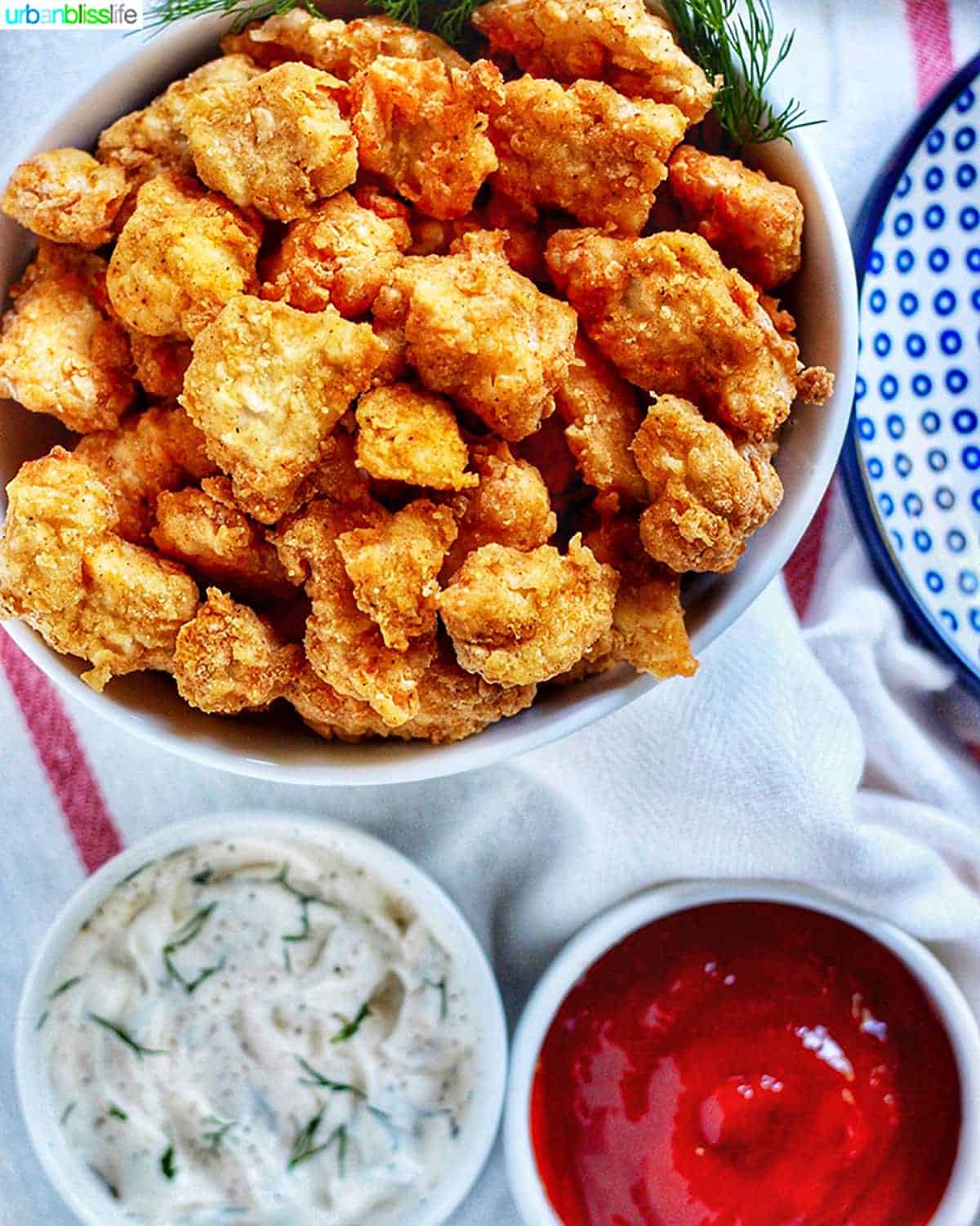 bowl full of crispy Air Fryer Popcorn Chicken with dipping sauces.