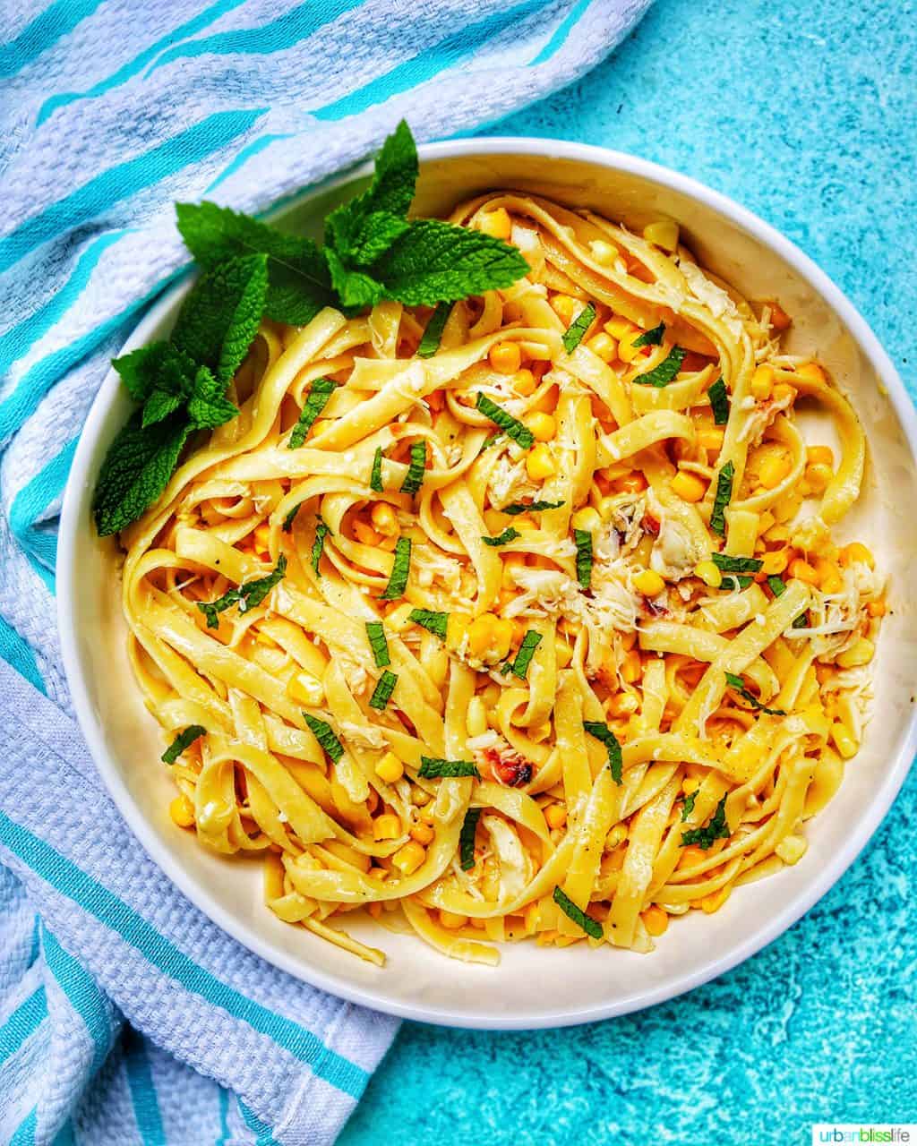 closeup of crab pasta in bowl with blue background