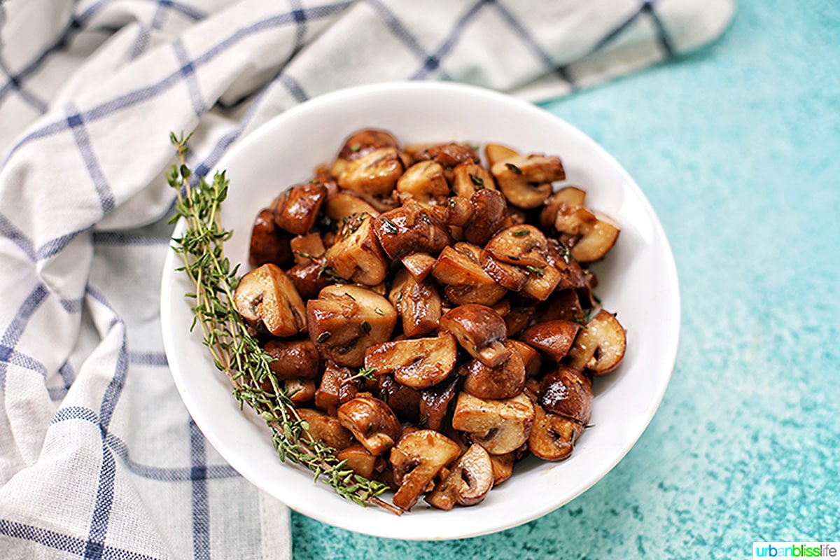 bowl of mushroom marsala with blue background and kitchen towel