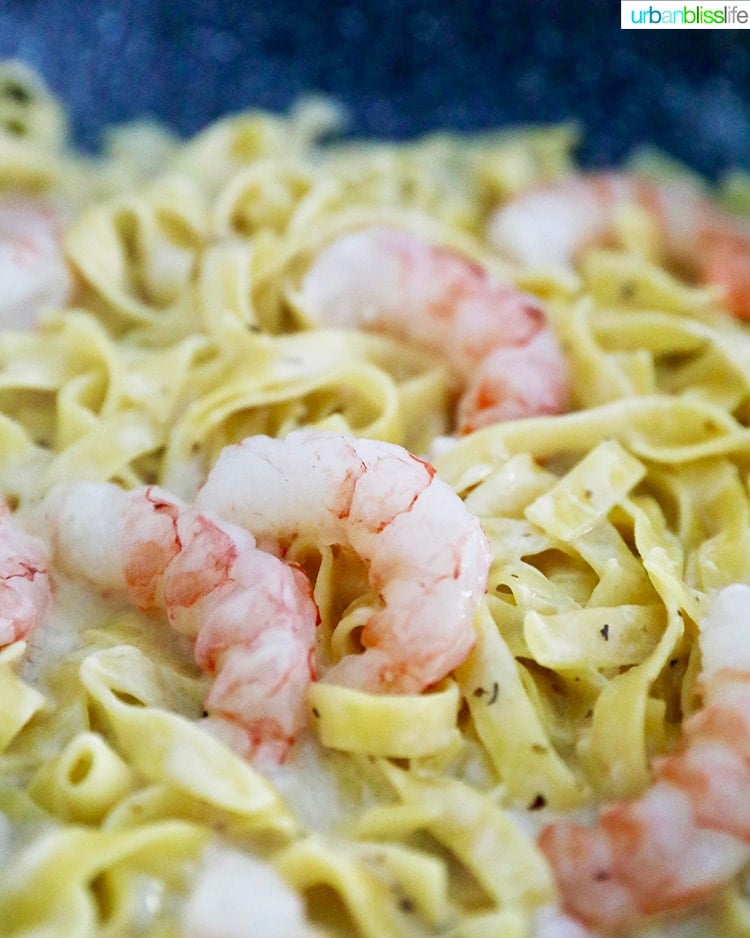 pasta and shrimp cooking in pan