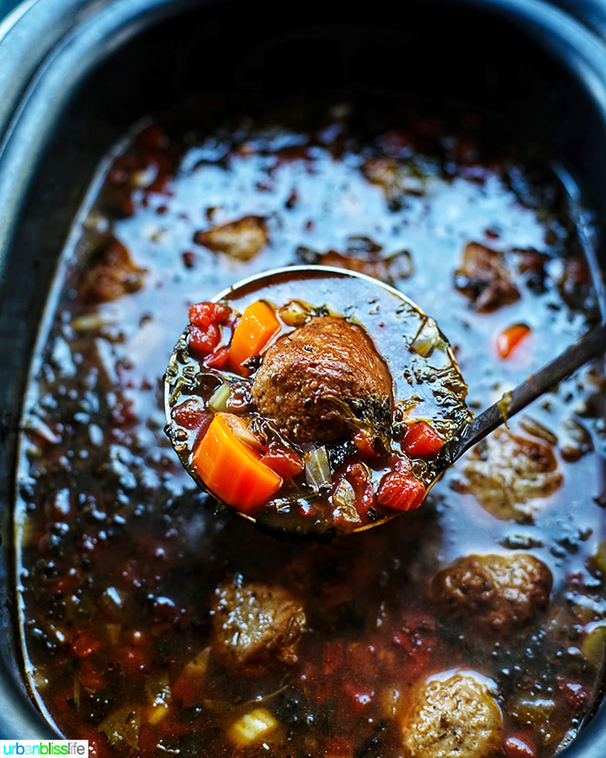 spoonful of meatball soup in slow cooker.