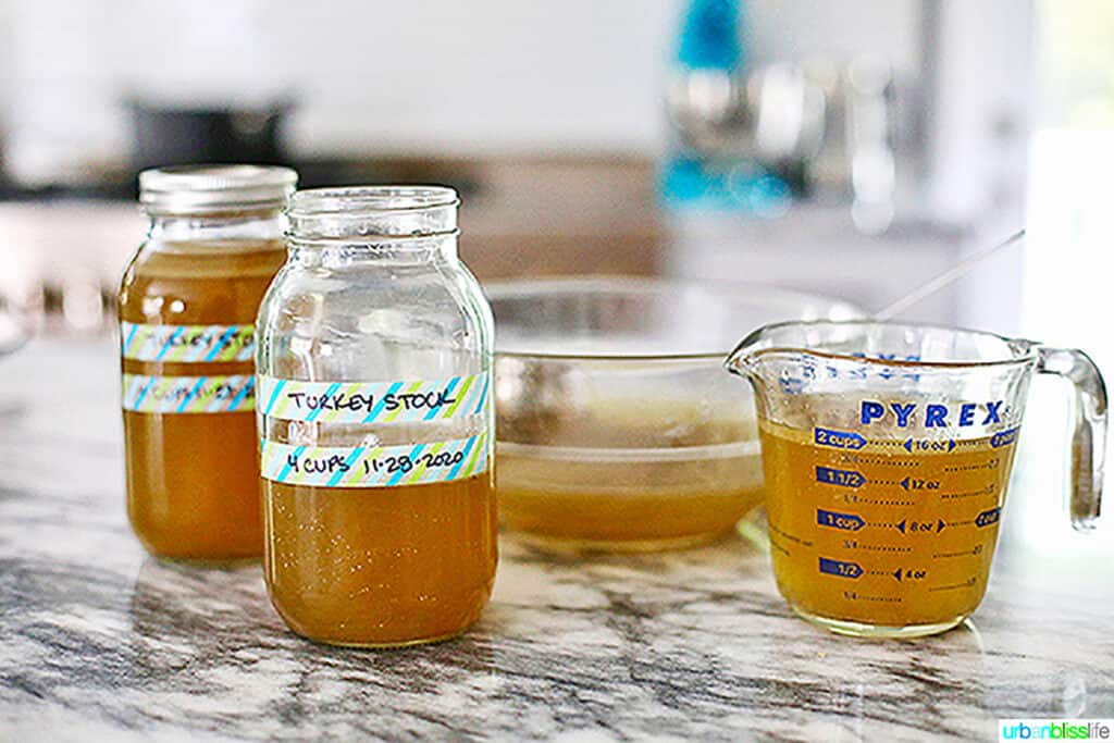 homemade turkey stock in measuring cup and mason jars labeled