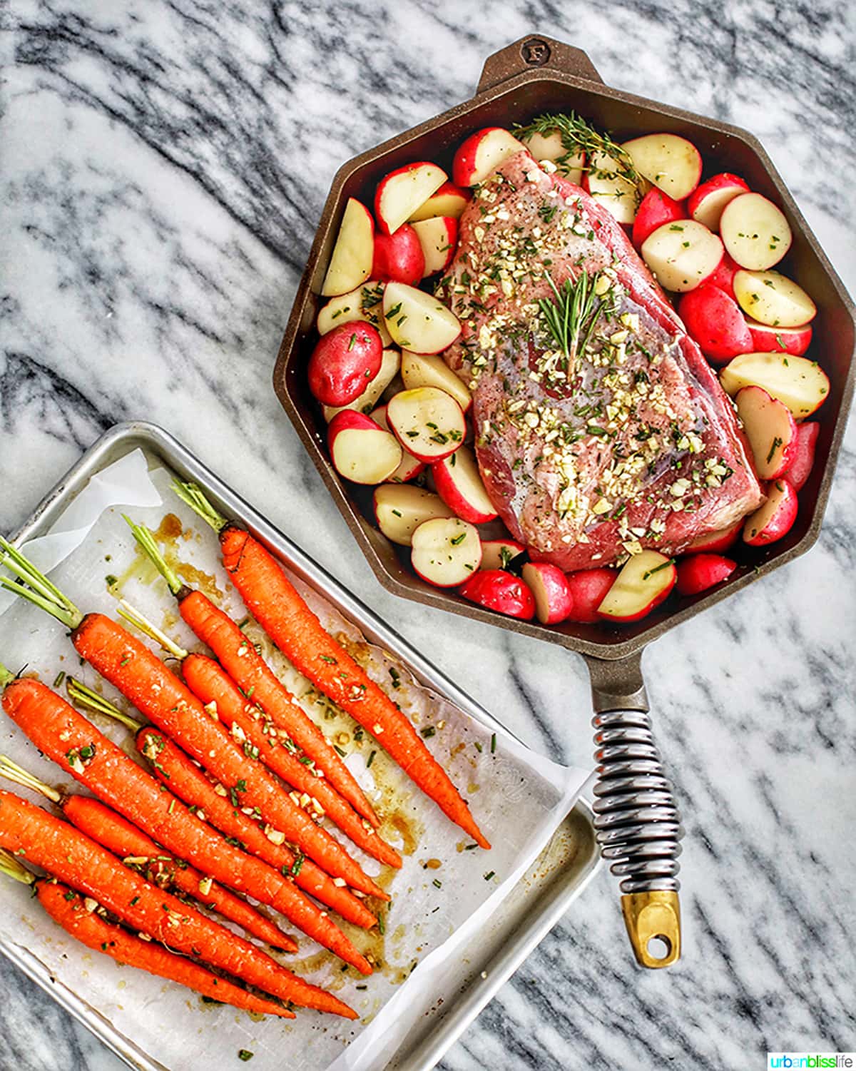 carrots in a baking sheet and beef roast and potatoes in a cast iron skillet