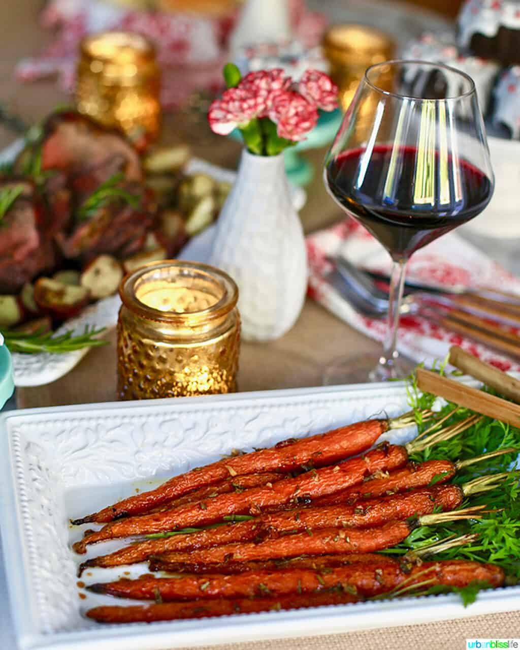 plate of garlic rosemary roasted glazed carrots on holiday table with wine