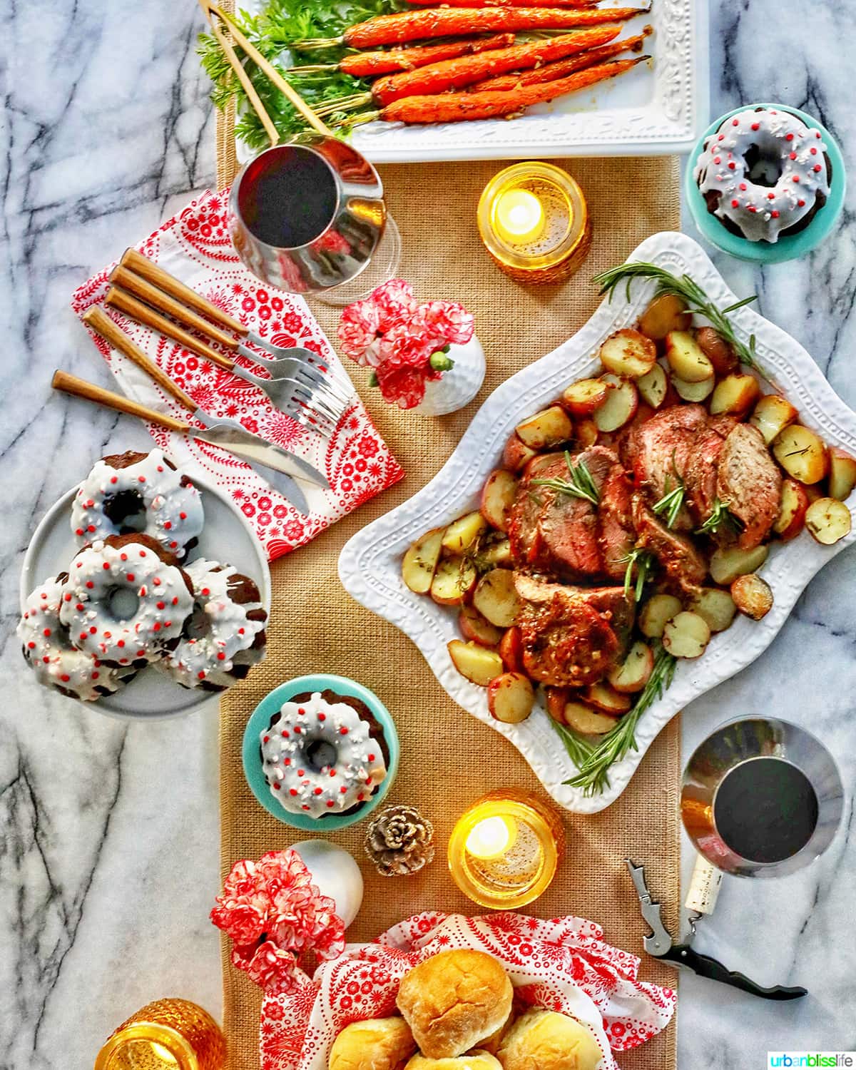 holiday dinner: beef roast, gingerbread bundt cakes, wine, dinner rolls, on a table decorated for the holidays