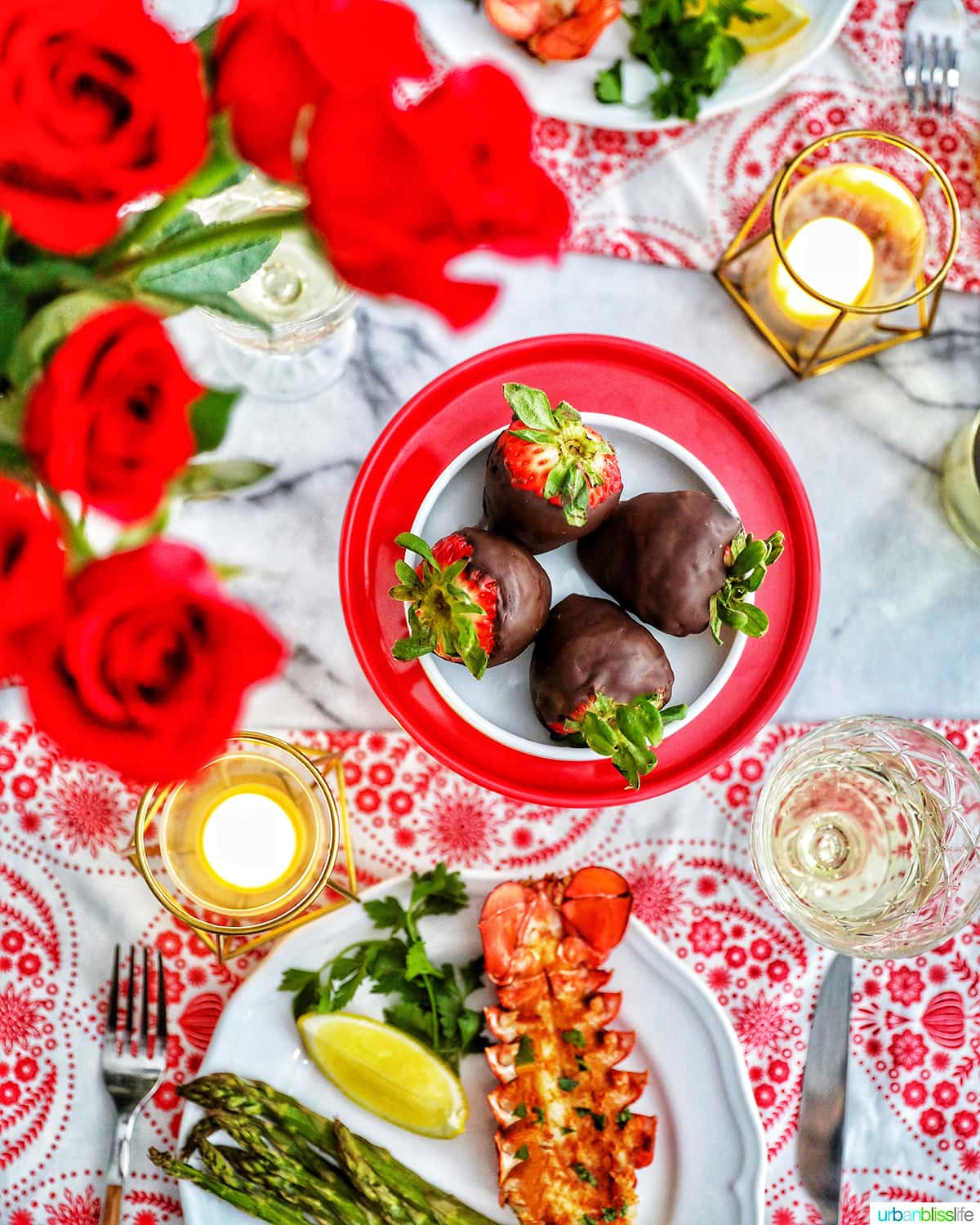 Valentine's Day dinner with lobster tails, chocolate covered strawberries, roses, candles, wine