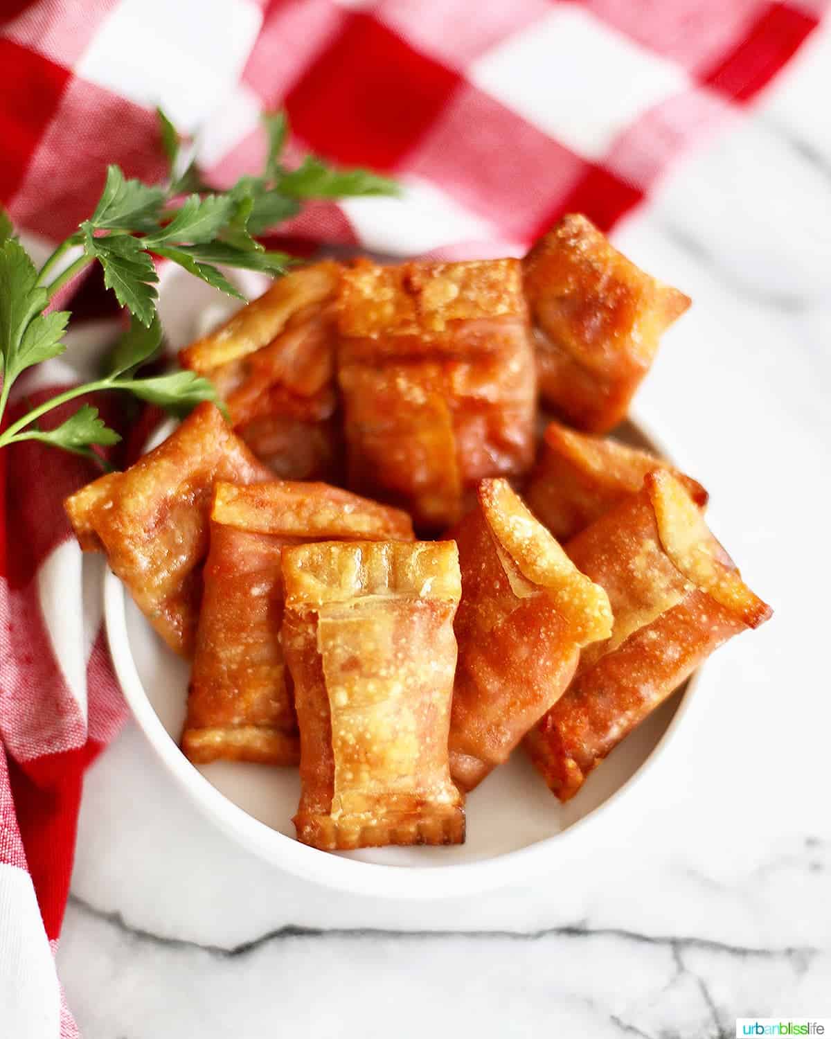 air fryer pizza rolls in a white bowl over a checkered tablecloth