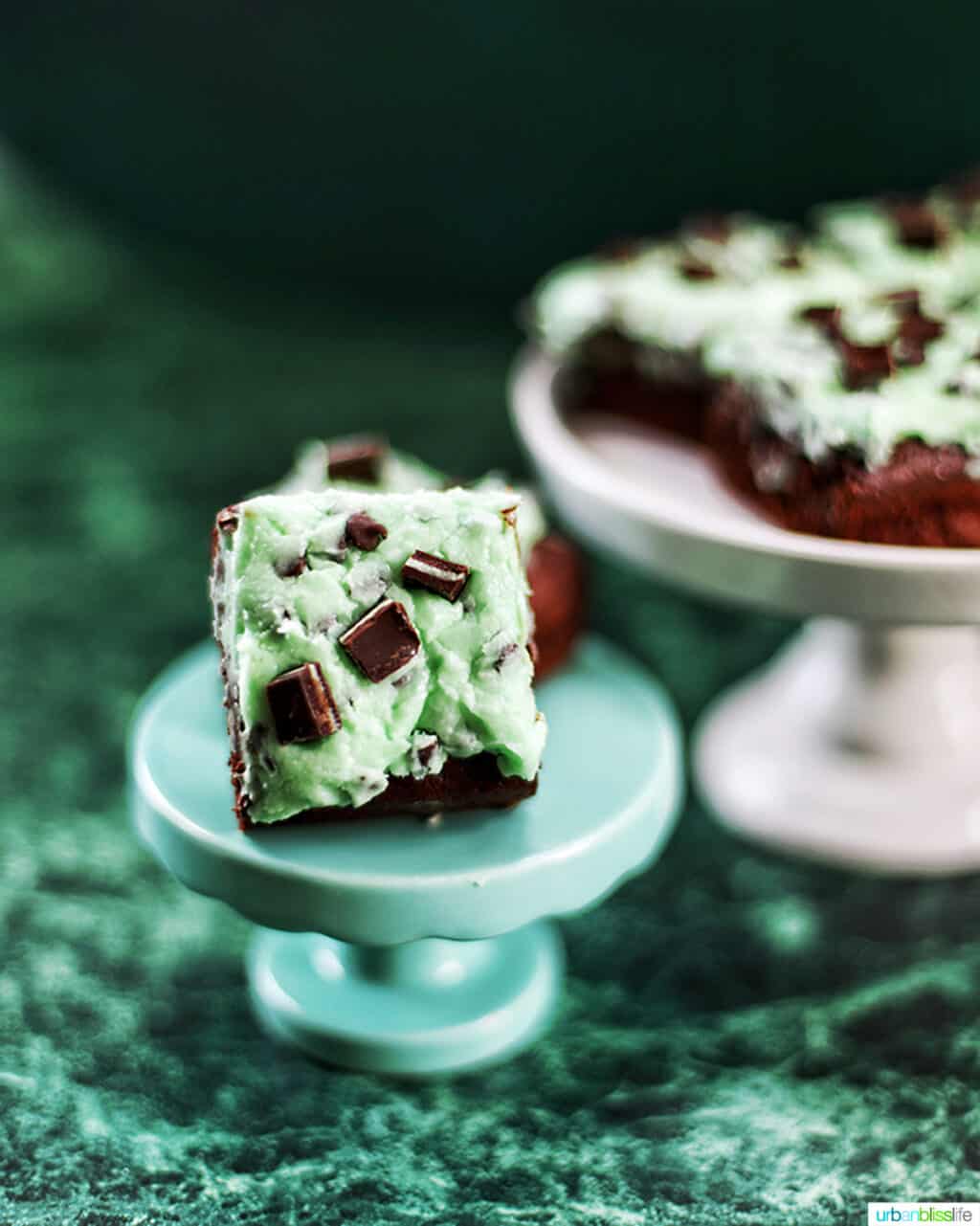 Mint Chocolate Chip Brownies on two cake pedestals on green background