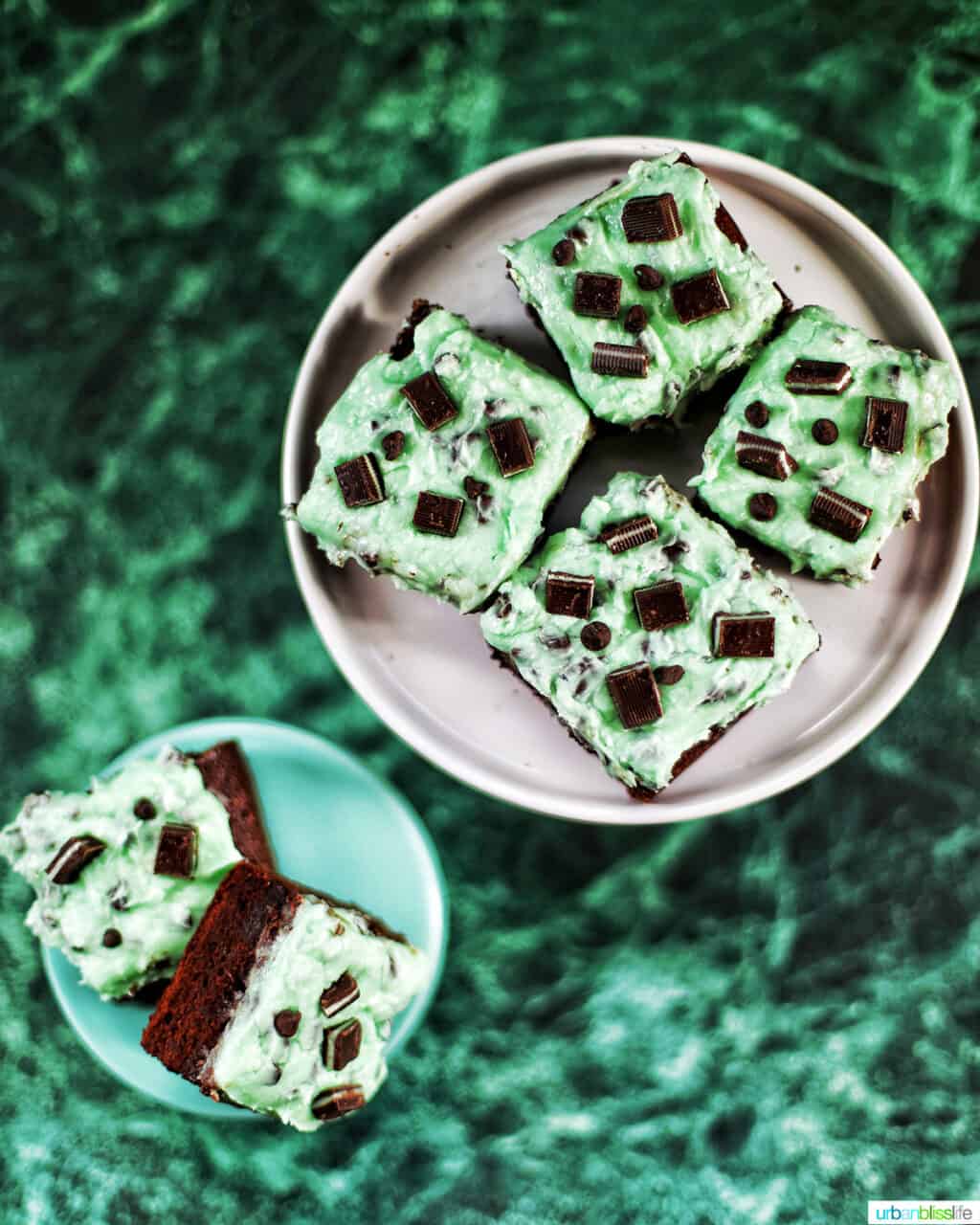 Mint Chocolate Chip Brownies on two cake pedestals on green background