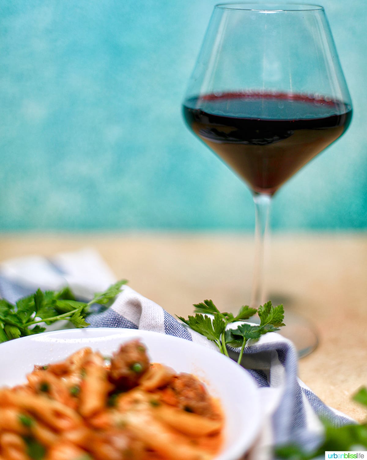 glass of red wine with Ninja Foodi Cajun Chicken Pasta