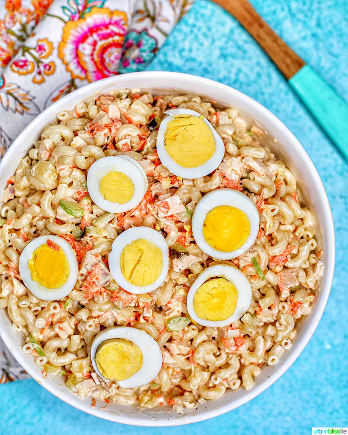 Filipino Macaroni Salad - macaroni, carrots, chicken, celery, pineapple, sliced hard-boiled egg- in a bowl.