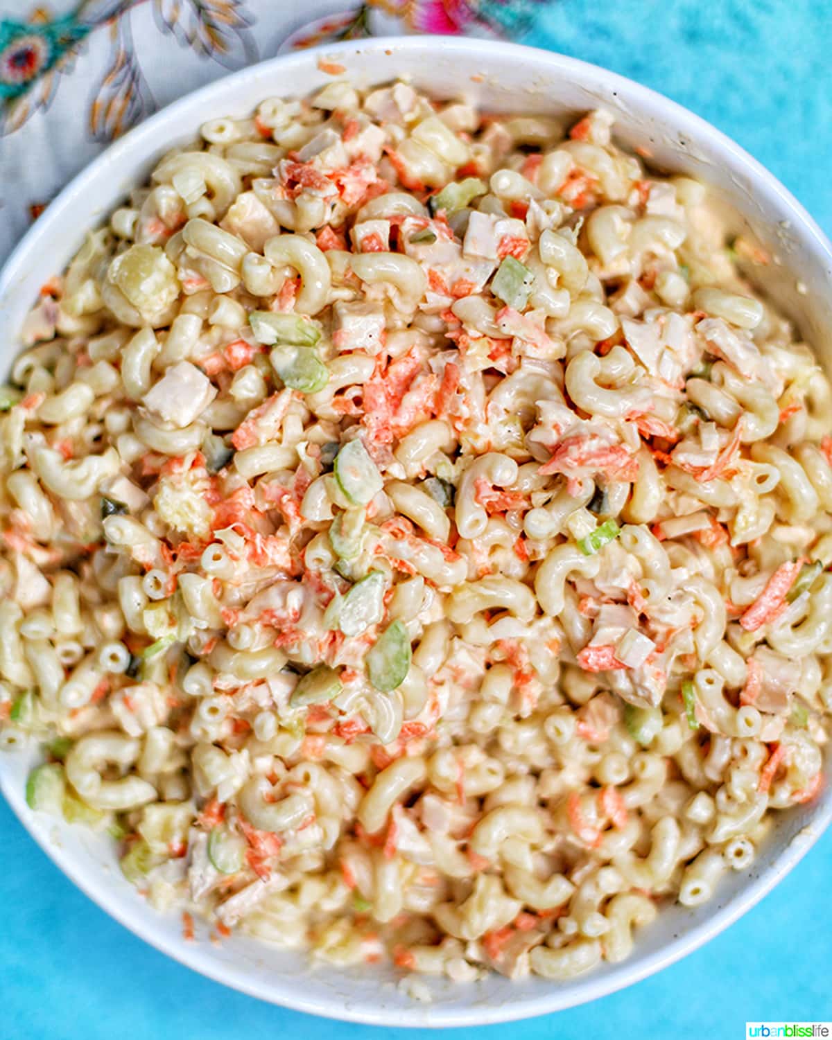 Filipino Macaroni Salad - macaroni, carrots, chicken, celery, pineapple, sliced hard-boiled egg- in a bowl.