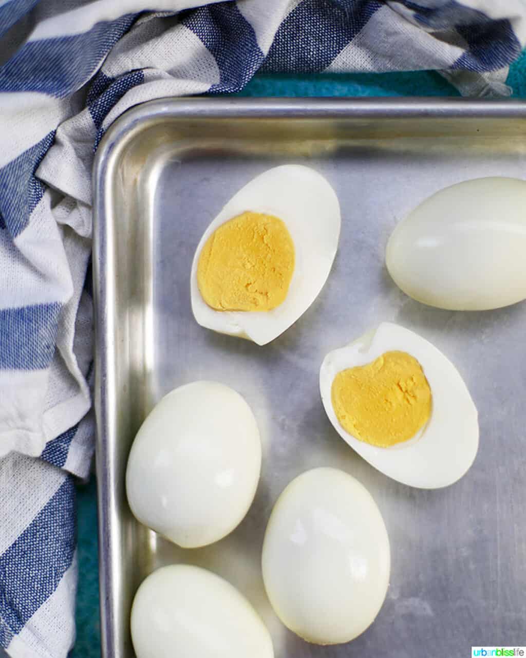 Hard boiled eggs one cut open on a baking sheet