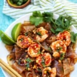 wide glass noodles with shrimp and chili lime oil sauce in a bowl with chopsticks