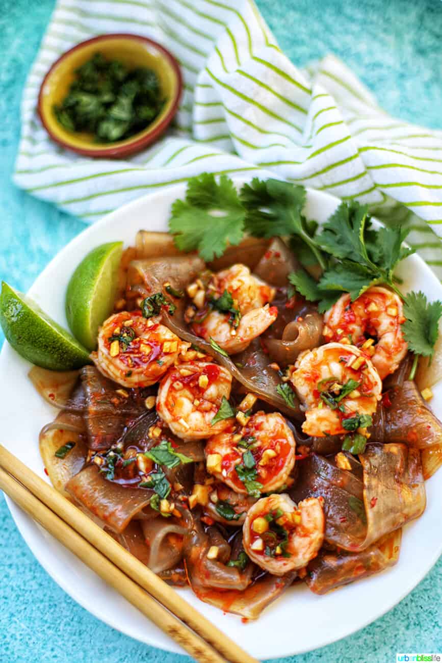 wide glass noodles with shrimp and chili lime oil sauce in a bowl with chopsticks