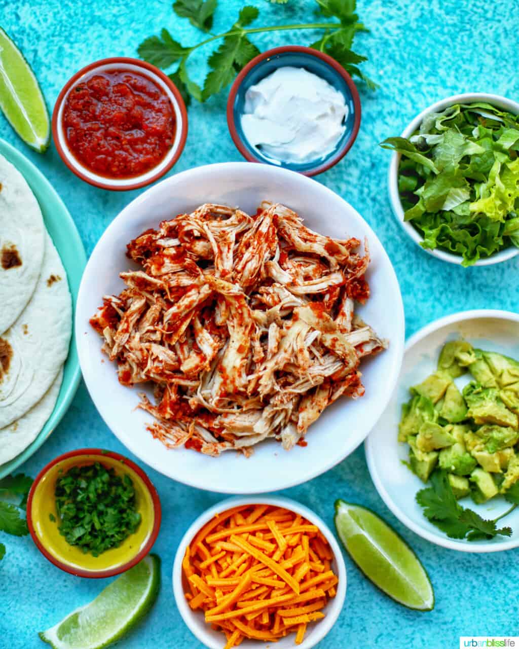 Instant Pot Salsa Chicken with salsa, sour cream, cheese, and other toppings for tacos