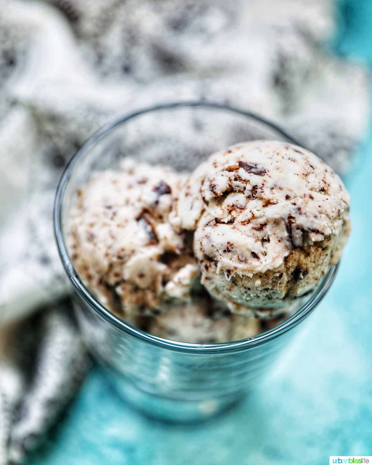 bowl of dairy-free chocolate chip ice cream on a bright blue table.