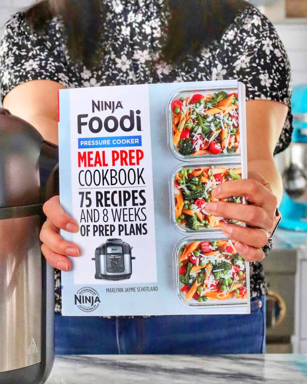 hands holding Ninja Foodi Meal Prep Cookbook