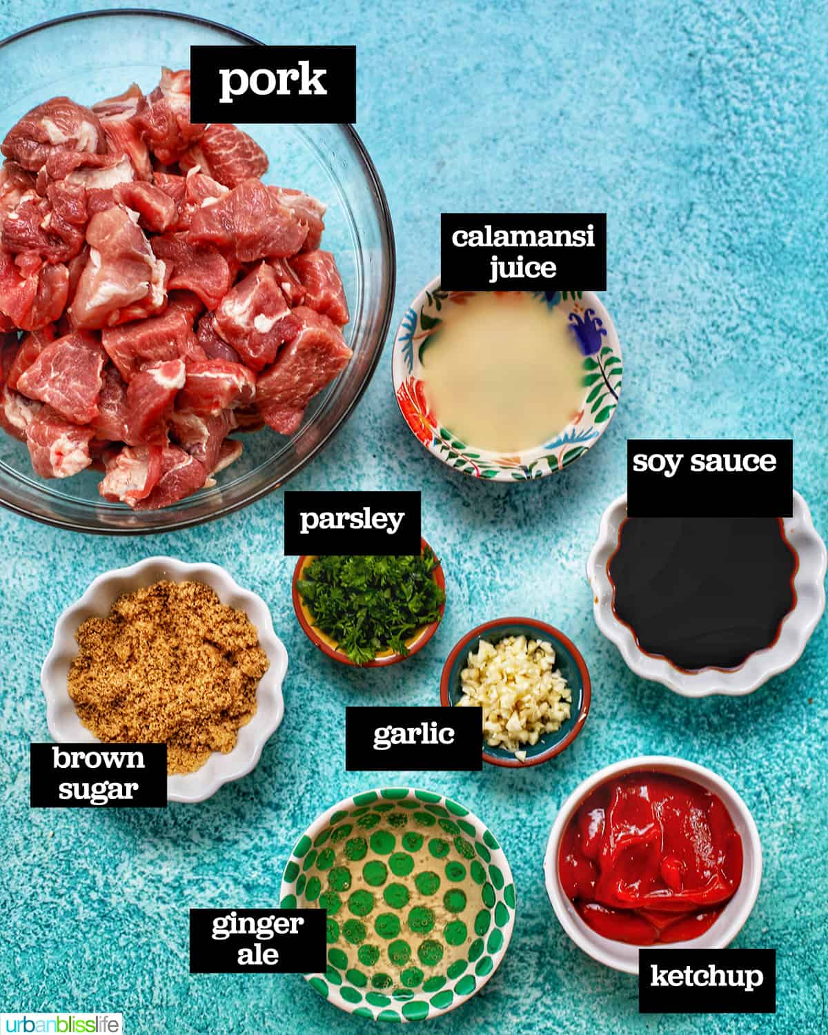 ingredients in individual bowls to make Filipino BBQ pork skewers on a bright blue background.