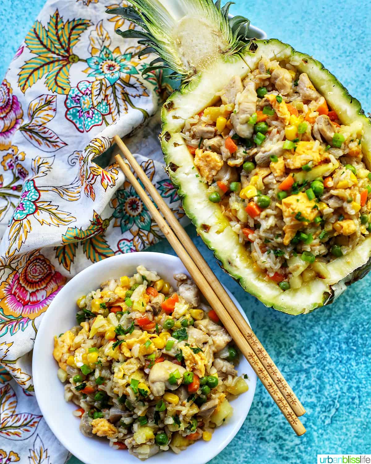 pineapple fried rice in hollowed out pineapple boat with bowl of fried rice