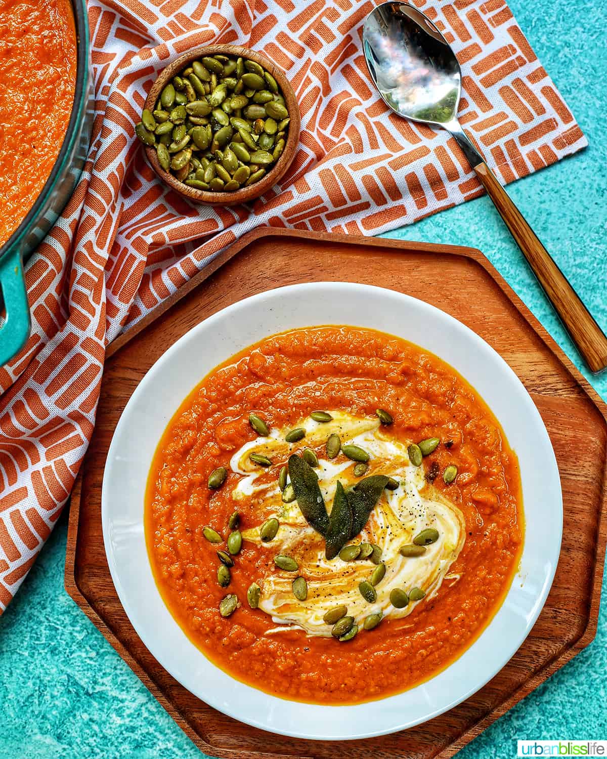 Bowl of Pumpkin soup topped with pepitas and cream.