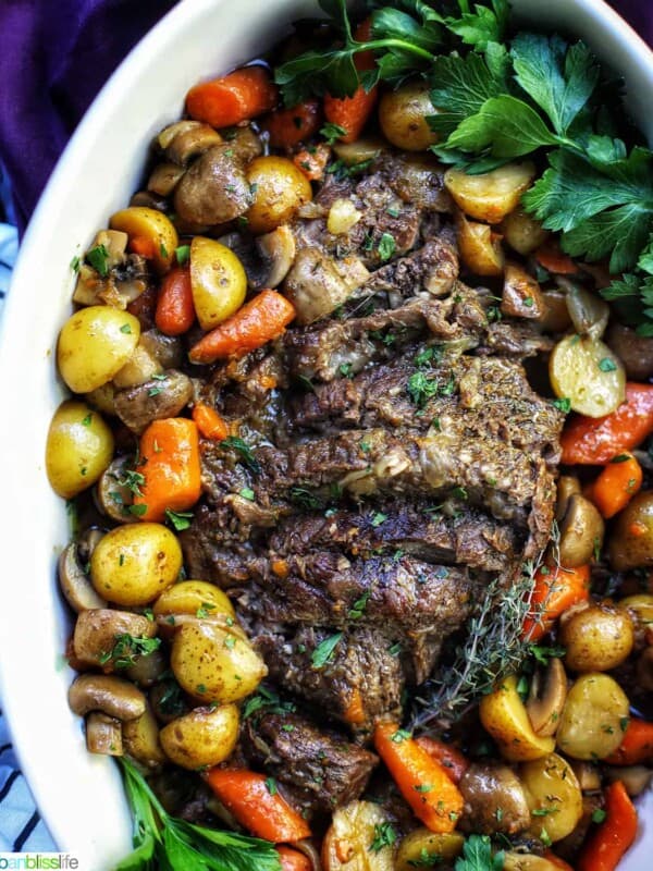 dutch oven pot roast with vegetables in a large white serving platter