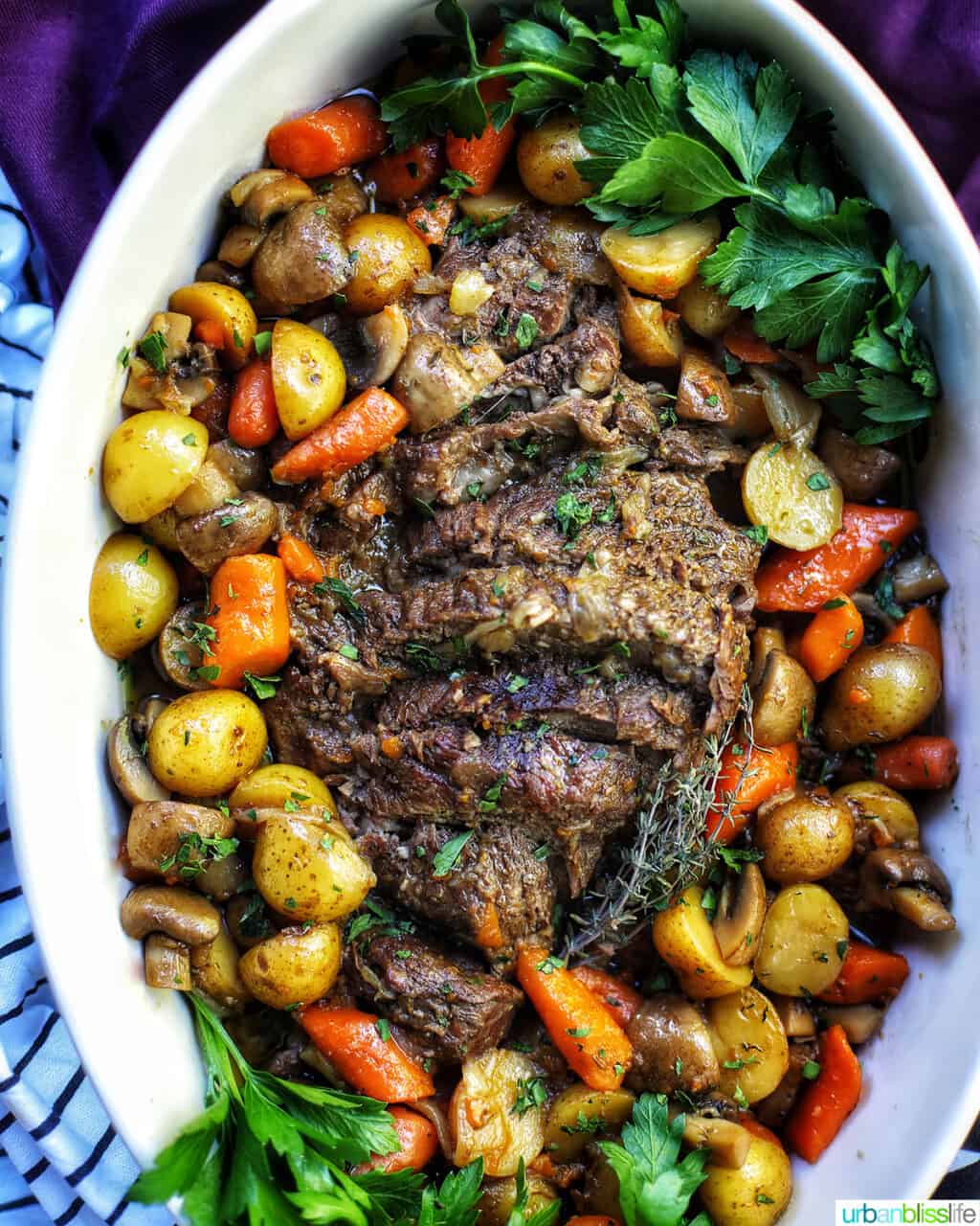 dutch oven pot roast with vegetables in a large white serving platter