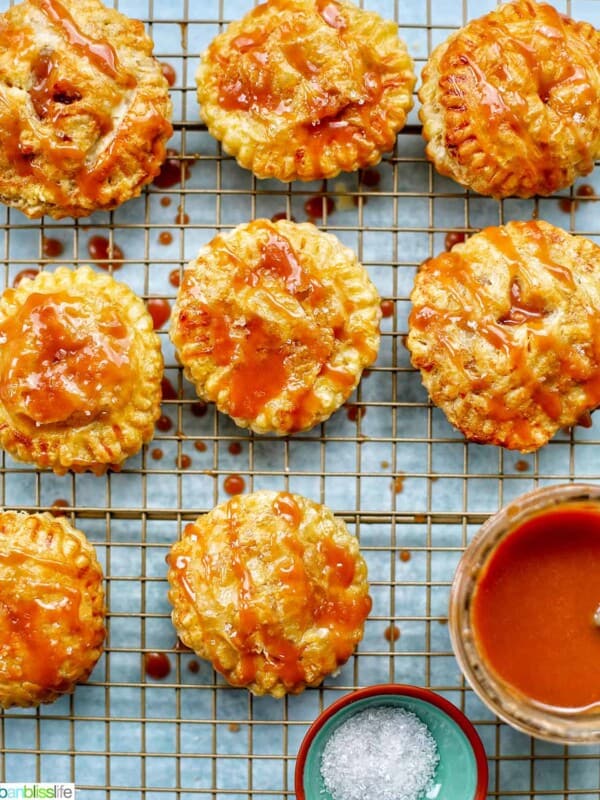 Air fryer apple hand pies on a rack with caramel