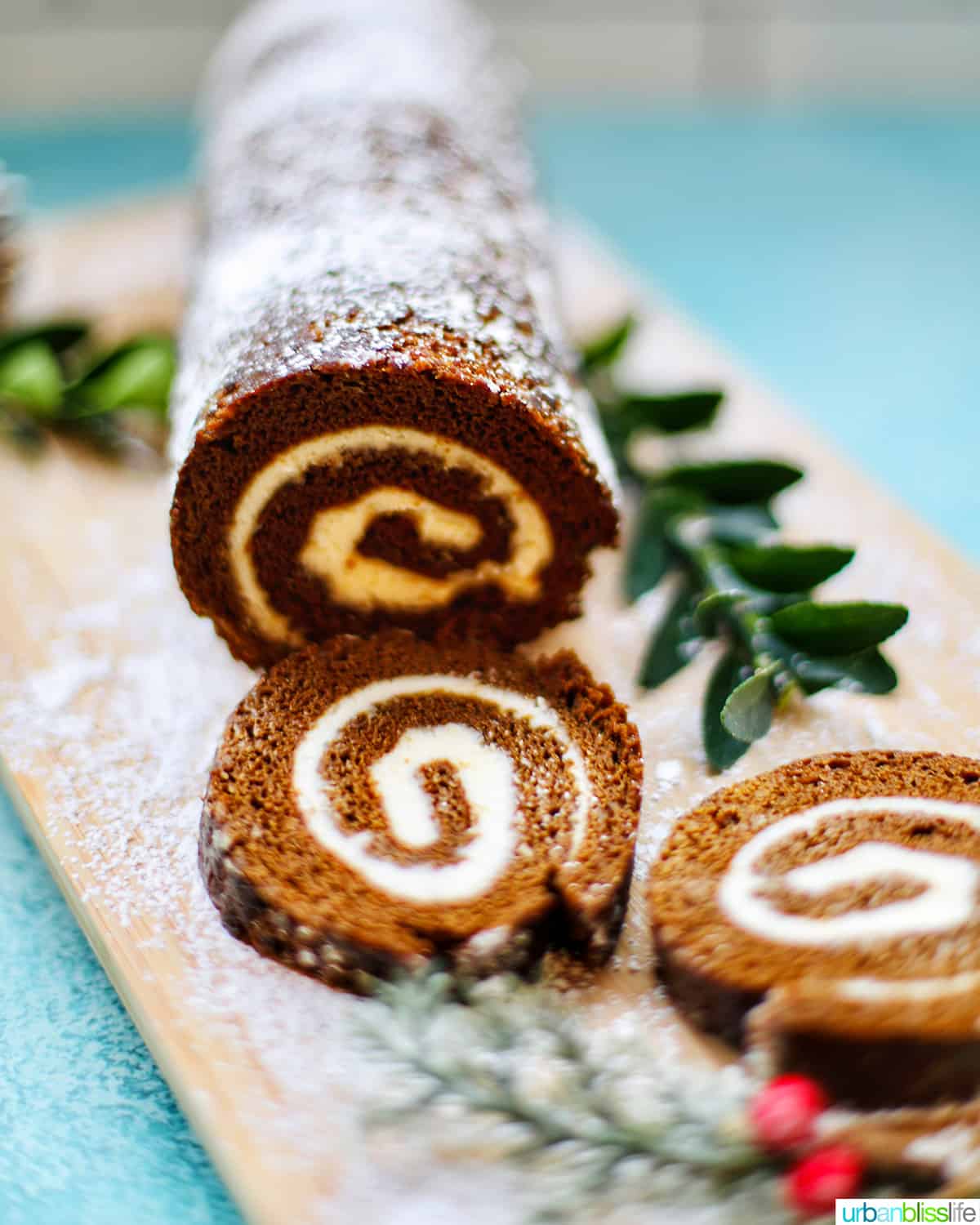 Gingerbread cake roll with holiday trimmings, cream cheese filling, and Christmas decorations.