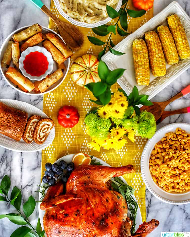 Thanksgiving table with turkey, mac and cheese, mashed potatoes, pumpkin roll, corn on the cob