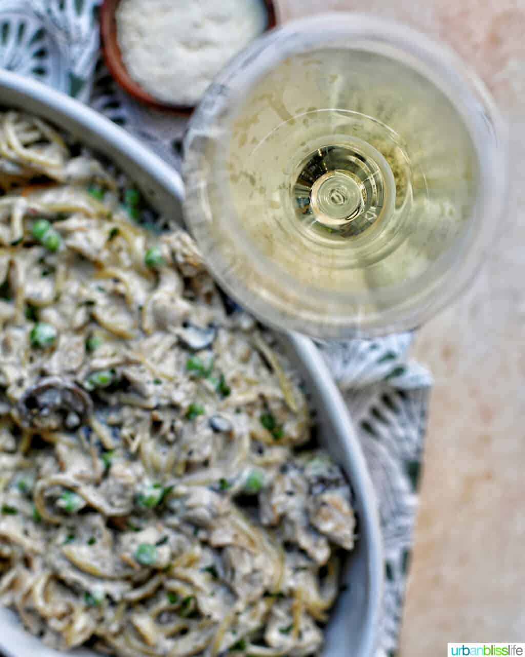 Turkey Tetrazzini in serving dish with glass of white wine