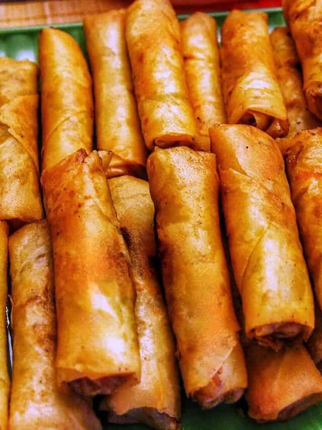 Tray of Filipino lumpia stacked on top of one another.