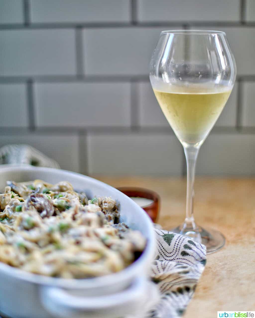 Turkey Tetrazzini in serving dish with glass of white wine