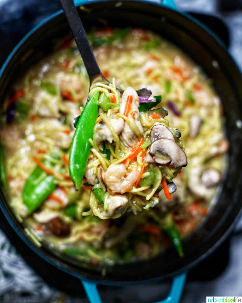 spoon full of adding shrimp to Filipino pancit canton noodles