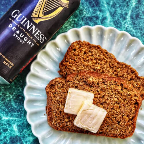 slices of Guinness brown bread with pats of butter and a Guinness beer