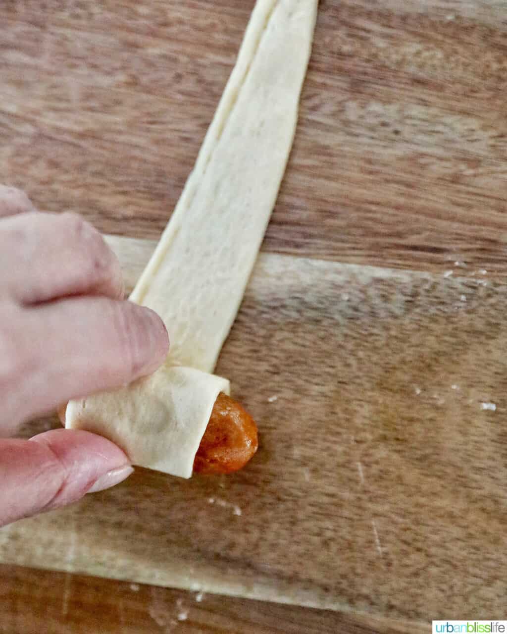 rolling up sausage in crescent dough