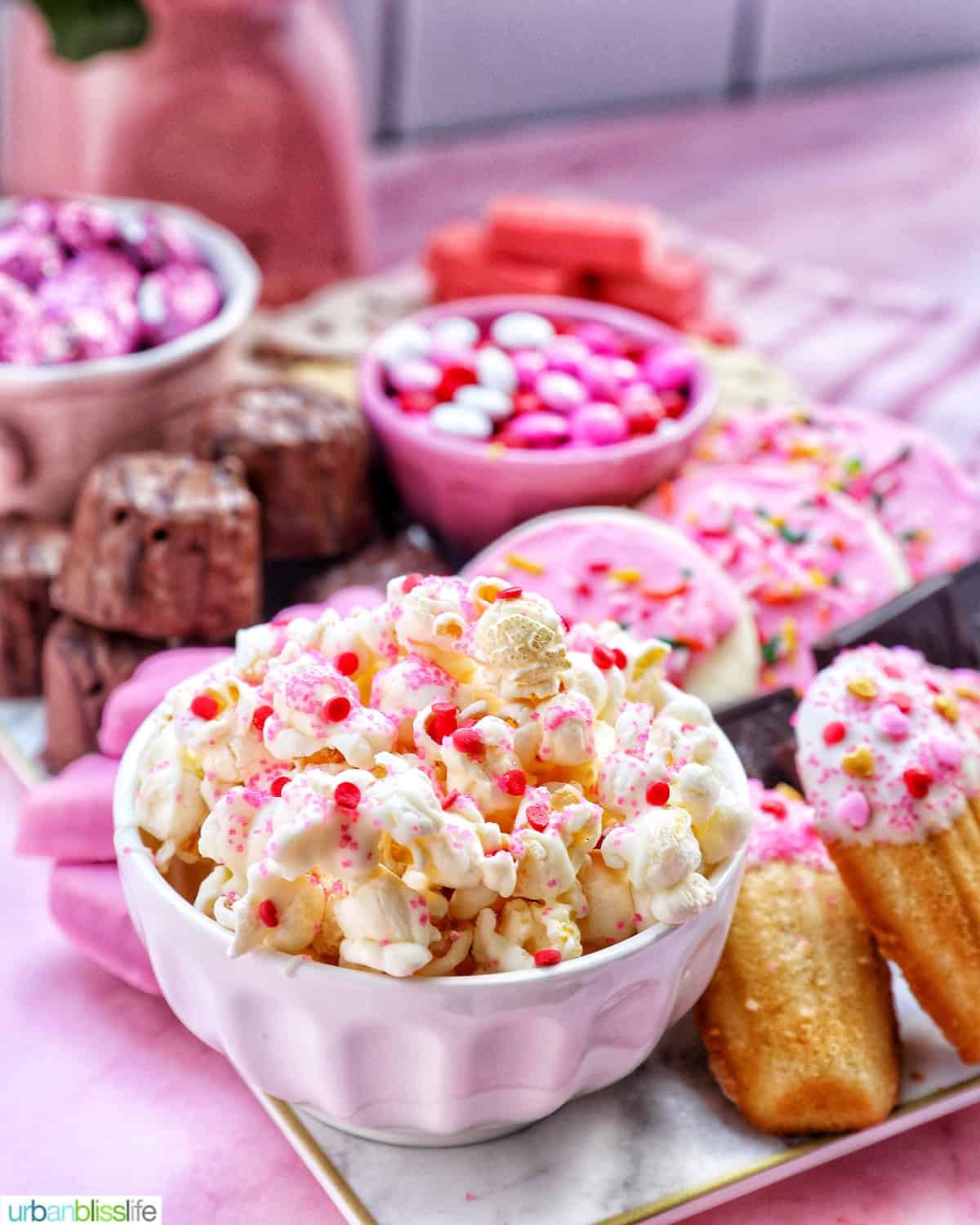 bowl of Valentine's Day Popcorn mix with other pink desserts