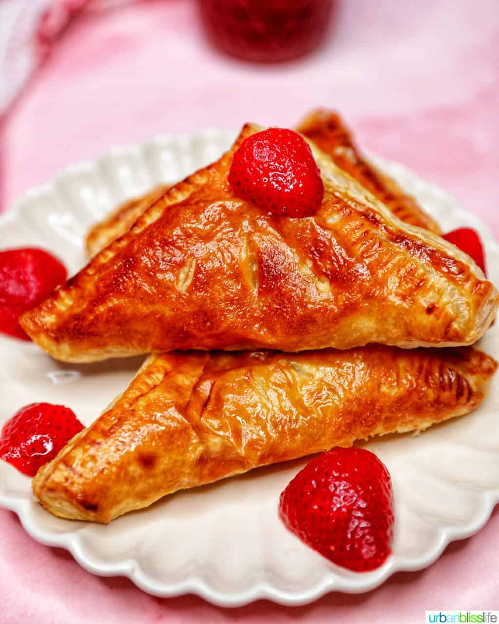 air fryer strawberry turnovers stacked on plate with strawberries