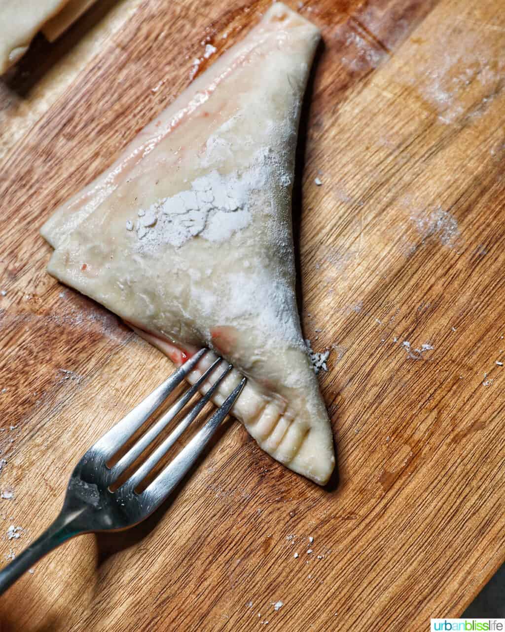 sealing edges of puff pastry with fork