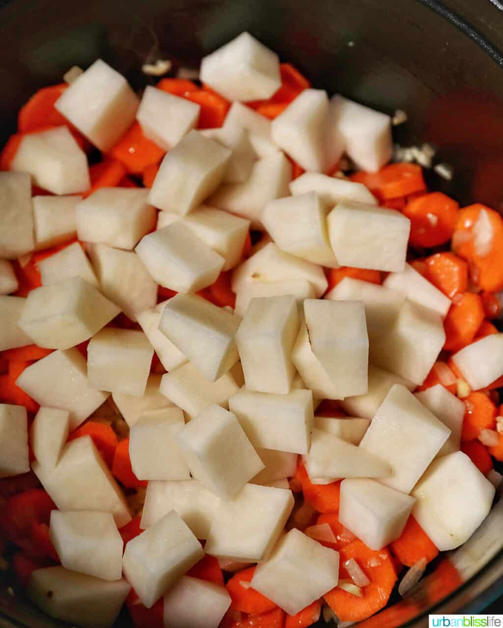adding potatoes to carrots