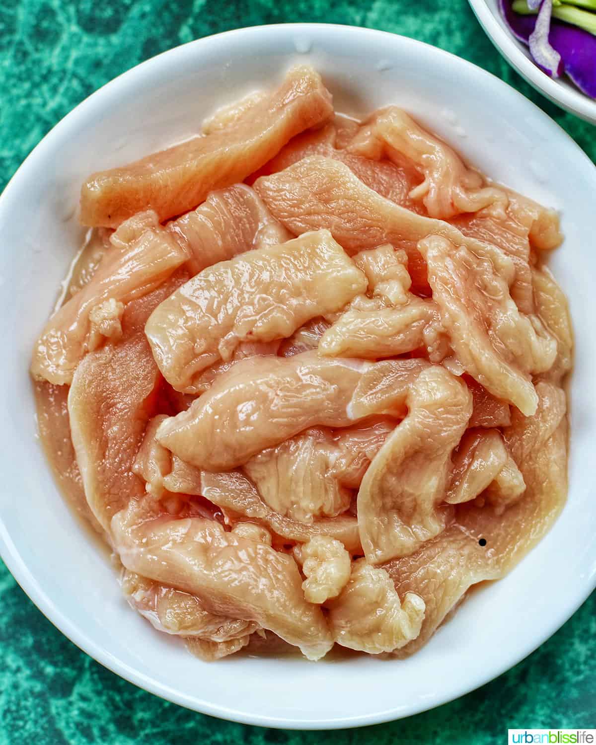 bowl of raw chicken to be used in Pancit Canton noodles recipes.