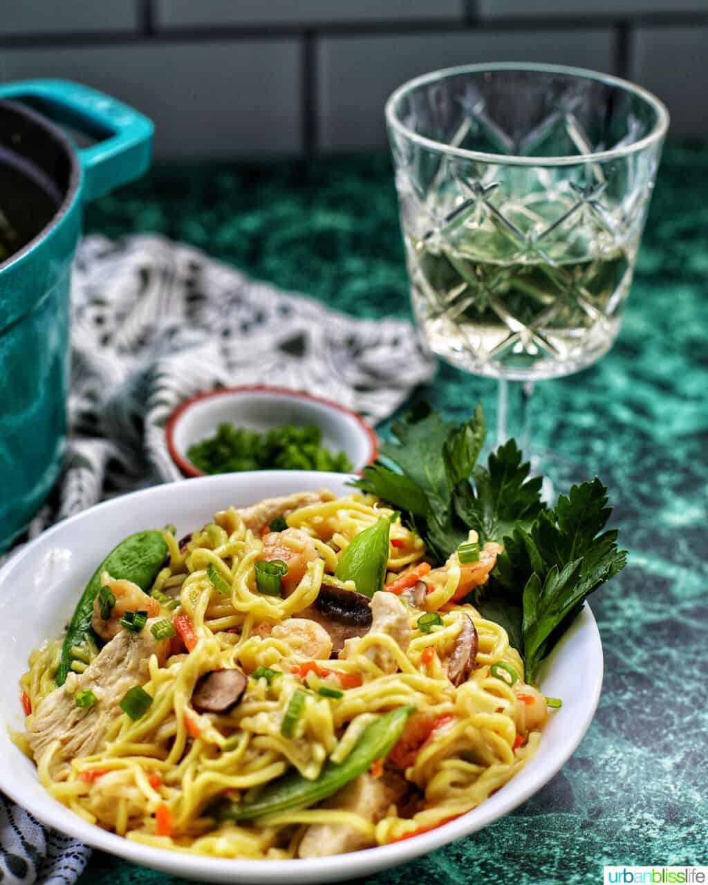 white wine with bowl of adding shrimp to Filipino pancit canton noodles 