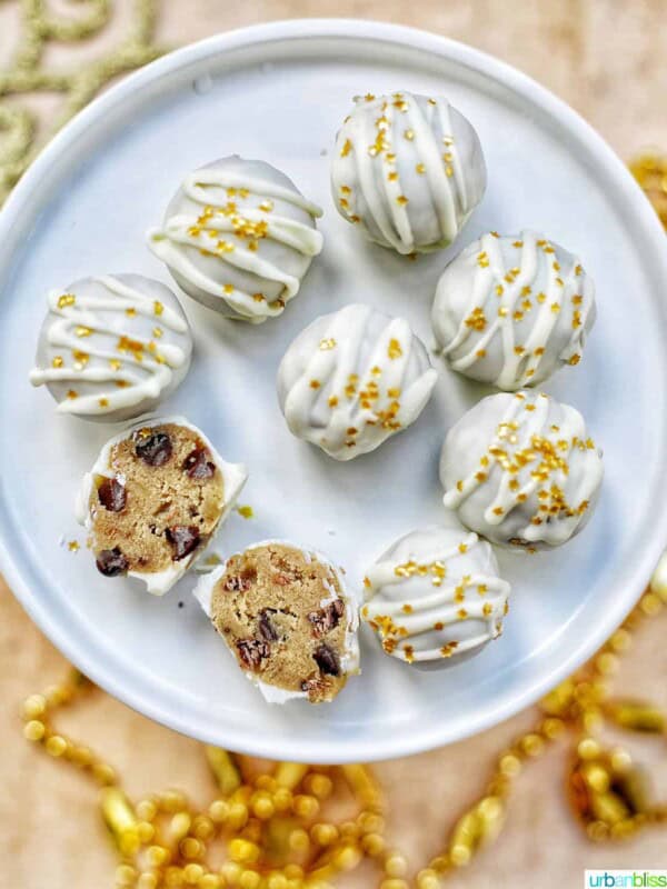 gold decorated white chocolate coated cookie dough truffles on a plate with two split open