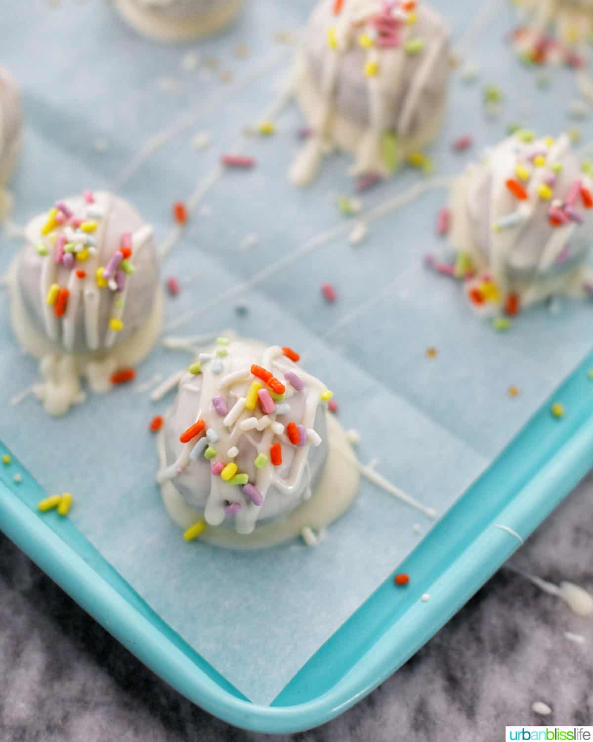 chocolate chip cookie dough truffles with spring sprinkles setting on baking sheet