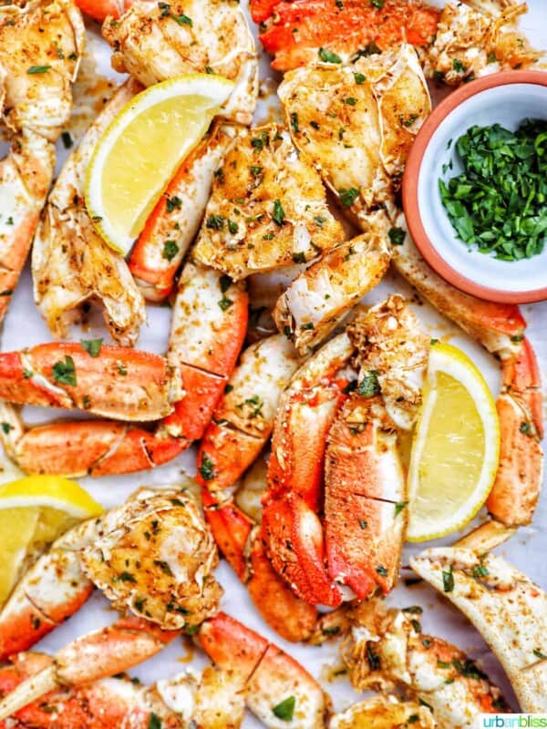 air fryer crab legs with lemon wedges and chopped parsley.