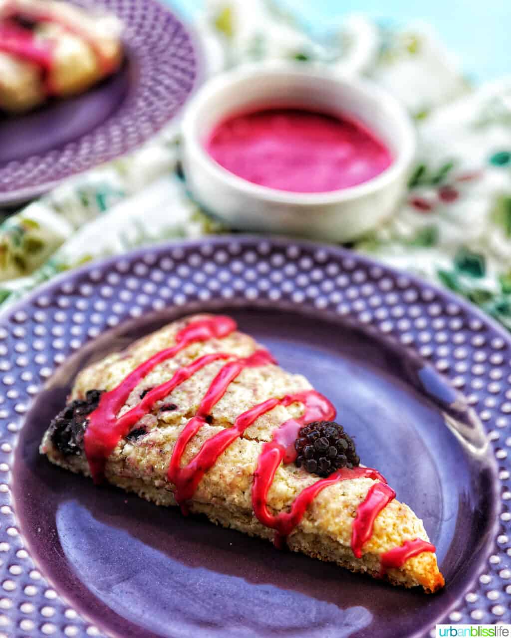 blackberry scones with blackberry glaze on purple plate