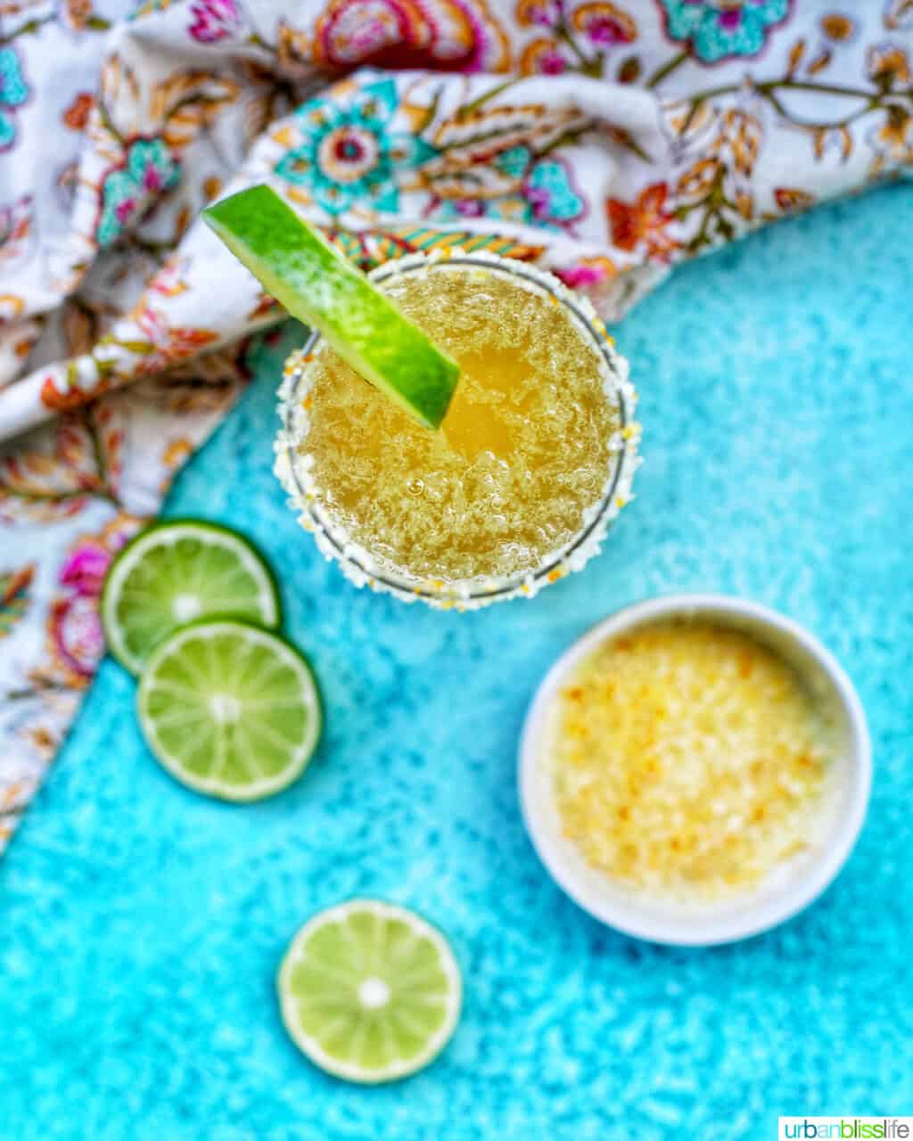 overhead of glass of champagne margarita with lime slices