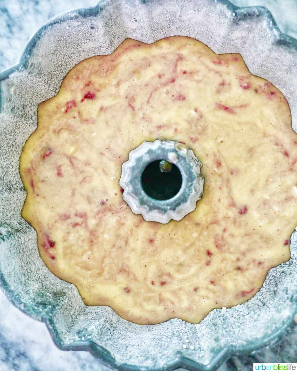 batter of white chocolate raspberry bundt cake poured into bundt cake pan