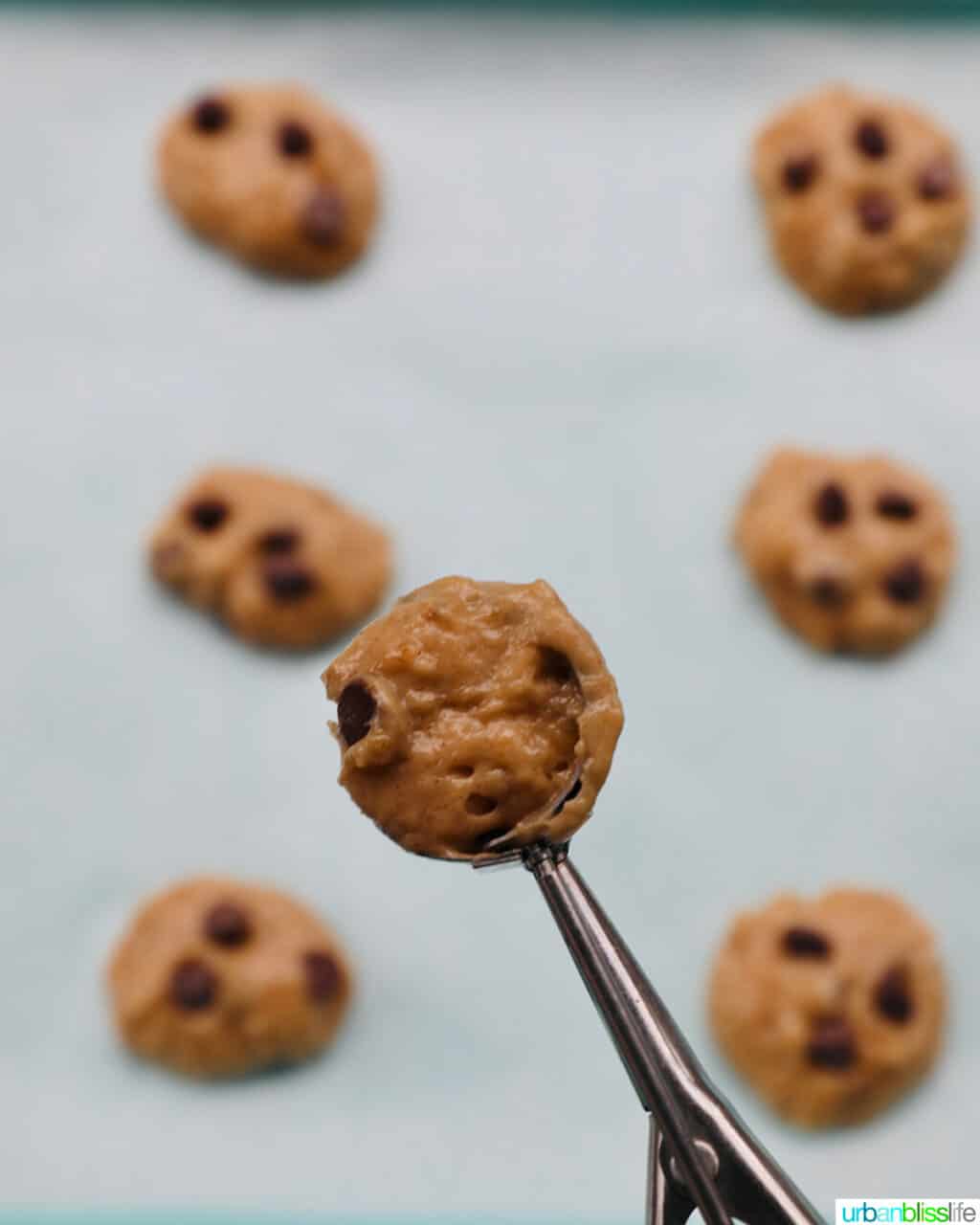 scooping banana bread cookie batter onto baking sheet